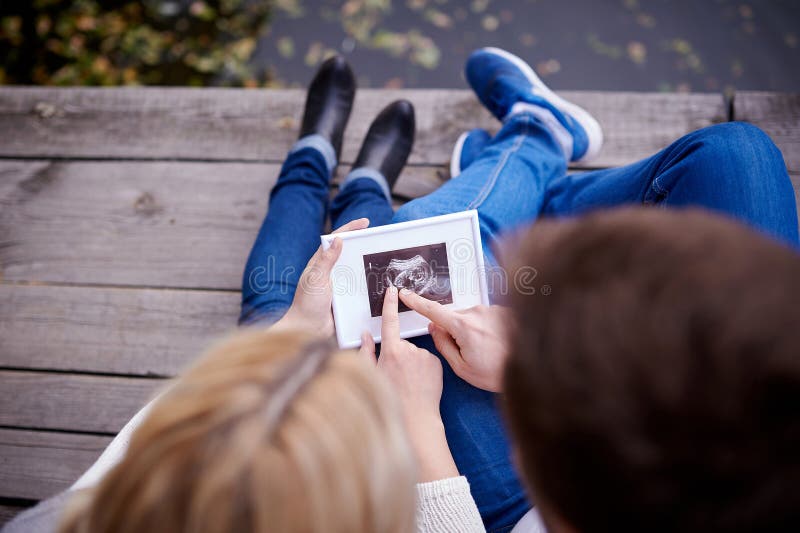 Happy couple are holding ultrasound scan of their baby royalty free stock photography Happy couple are holding ultrasound scan of their baby royalty free stock photography