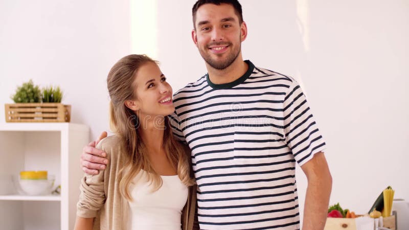 Happy couple hugging at home kitchen