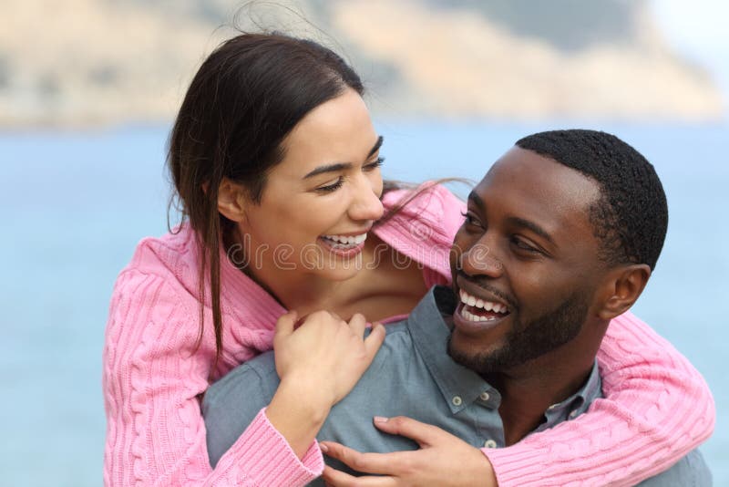 Happy couple joking and laughing on the beach