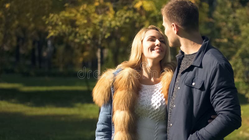 Happy couple looking at each other, autumn stroll in beautiful park, true love