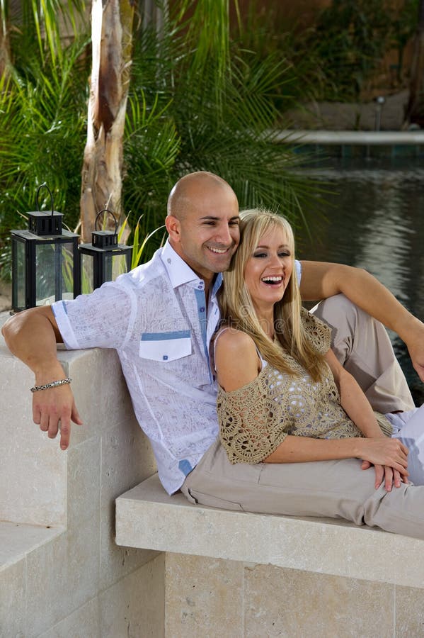 Happy couple lounging by the pool