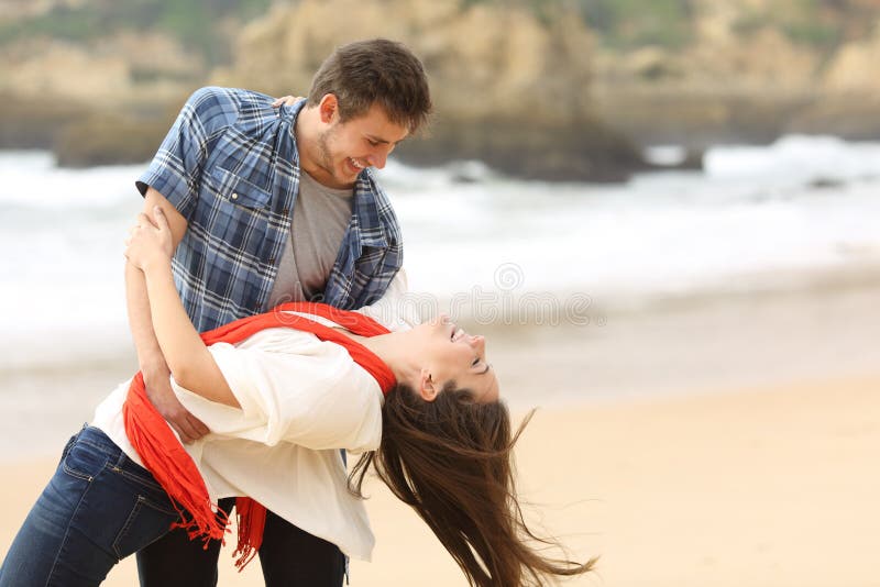 Happy couple in love joking on the beach