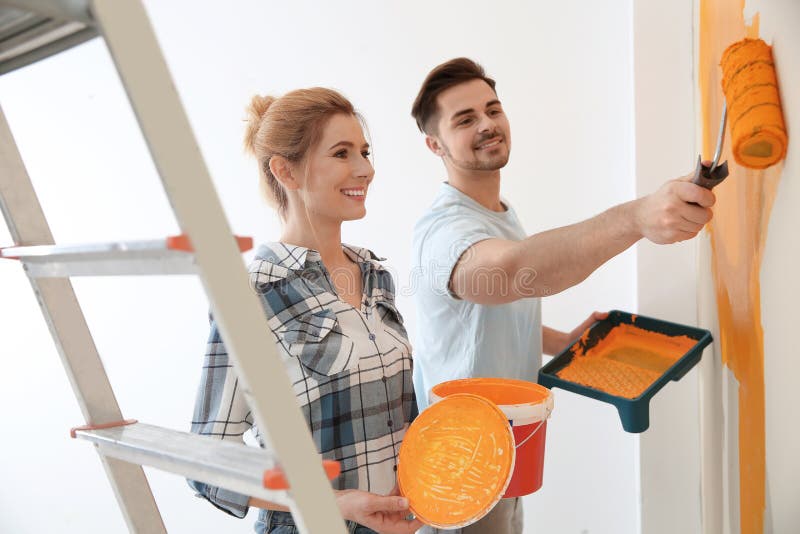 Happy couple painting wall. Home repair