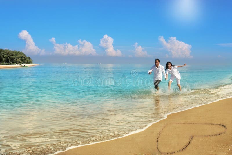 Happy couple running at beach