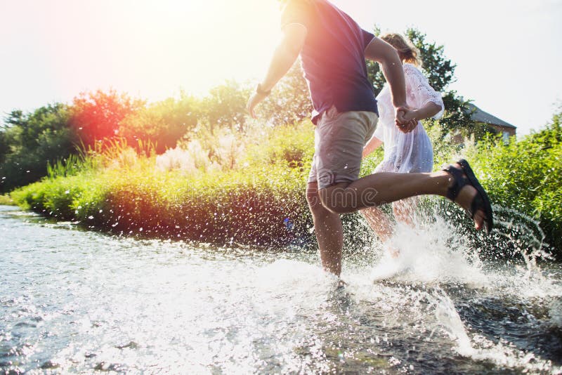 Happy couple running in shallow water stock images