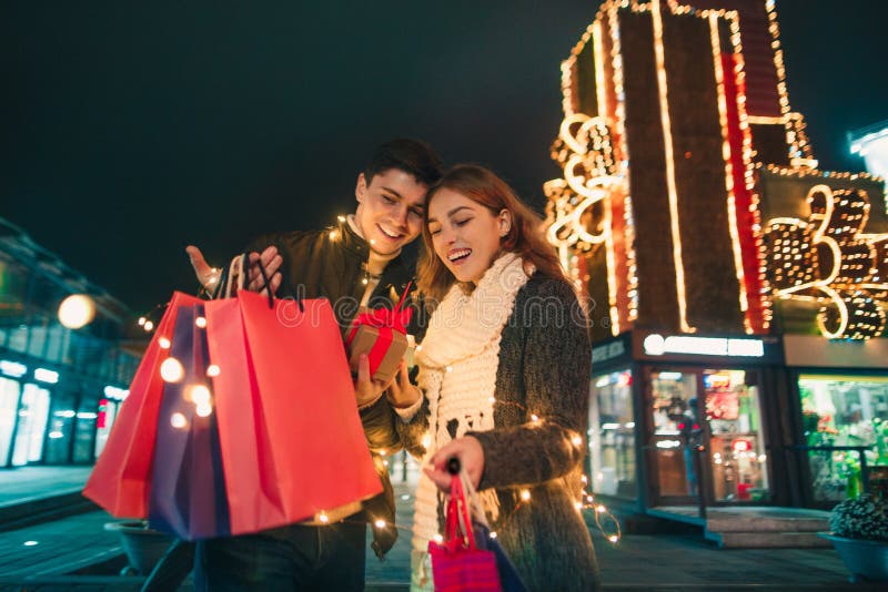 The happy couple with shopping bags enjoying night at city background