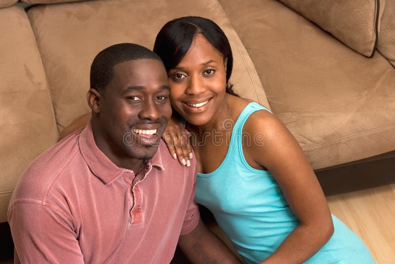 Happy Couple Sitting in front of Couch- Close Up