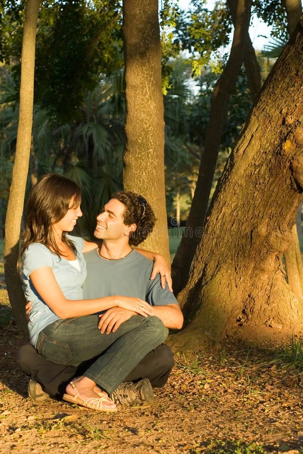 Happy Couple Sitting in the Woods. Vertical