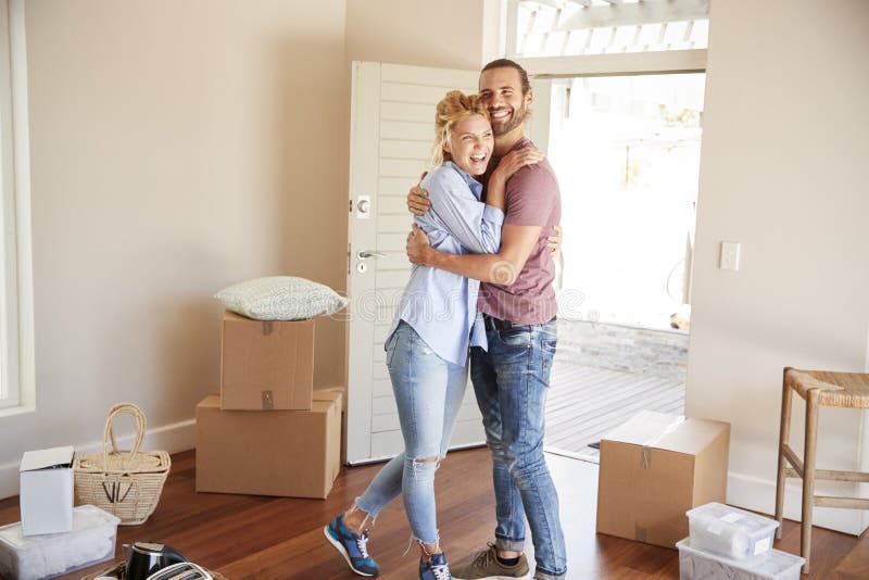 Happy Couple Surrounded By Boxes In New Home On Moving Day royalty free stock photos Happy Couple Surrounded By Boxes In New Home On Moving Day royalty free stock photos