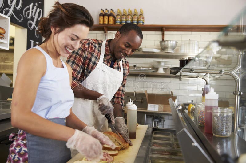 Happy couple working behind the counter at a sandwich bar royalty free stock image