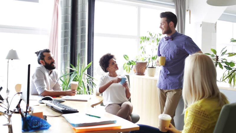Happy creative team drinking coffee in office stock video footage