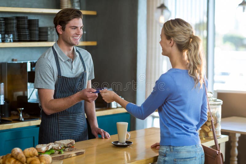 Happy customer giving credit card to waiter