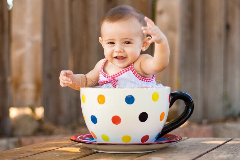 Happy and cute baby girl in giant teacup