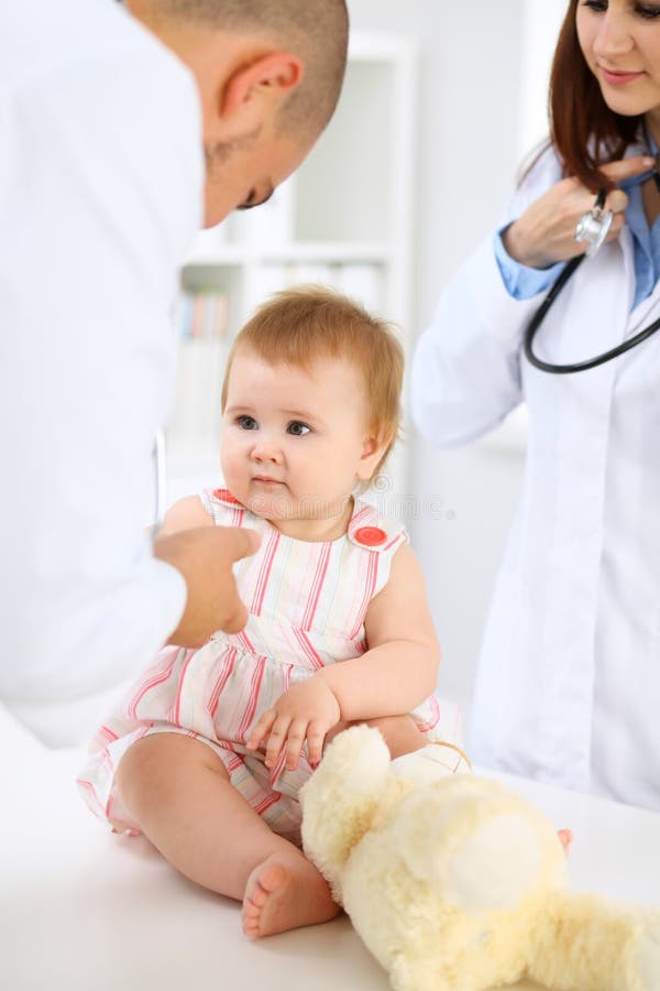 Happy cute baby after health exam at doctor`s office. Pediatrician, person.