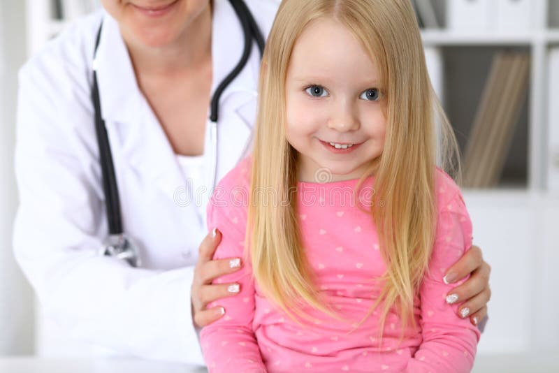 Happy cute baby after health exam at doctor`s office. Nurse, hospital.