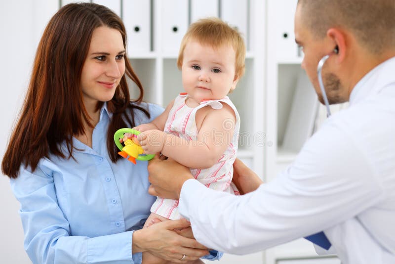 Happy cute baby with her mother at health exam at doctor`s office. Nurse, child.