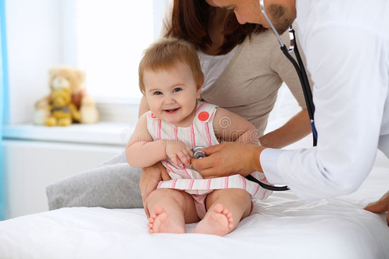 Happy cute baby with her mother at health exam at doctor`s office. Hospital, friendly.