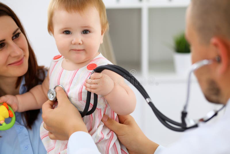 Happy cute baby with her mother at health exam at doctor`s office. Girl, lovely.