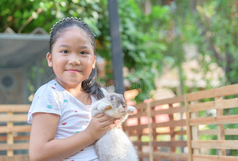 Happy cute girl hug rabbit in farm stock image Happy cute girl hug rabbit in farm stock image