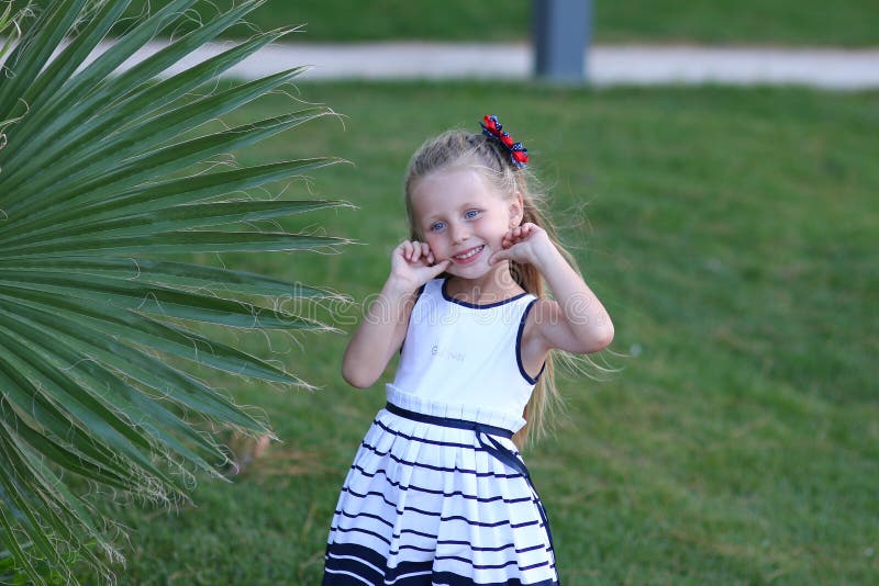 Happy cute little girl in palm summer hot day in the holidays stock photo Happy cute little girl in palm summer hot day in the holidays stock photo
