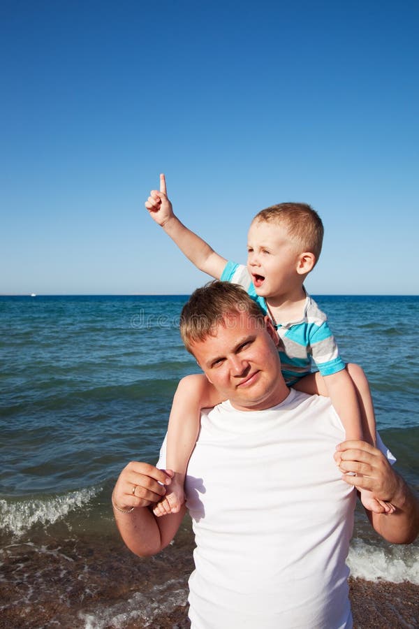 Happy dad and son having fun on the beach