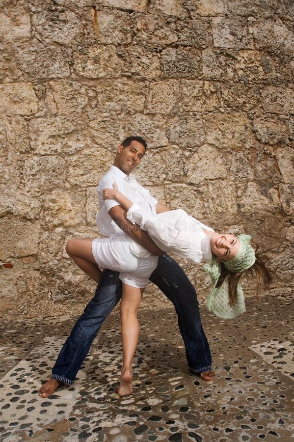 Portrait of beautiful couple dancing against stone background. Portrait of beautiful couple dancing against stone background