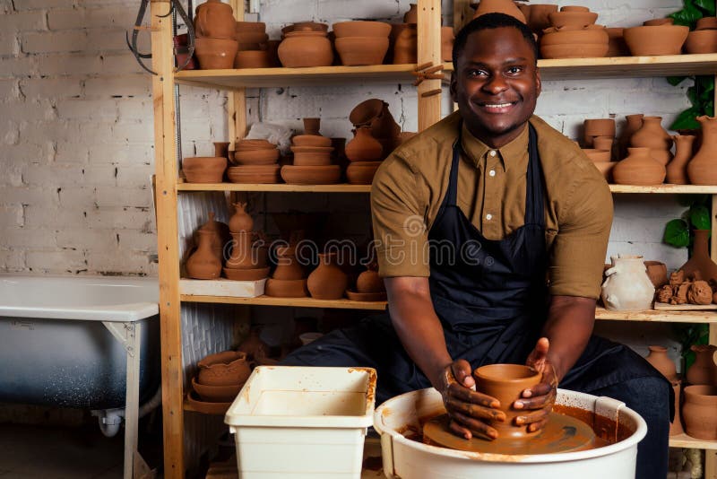 potter professional happy man working with brown clay in workshop