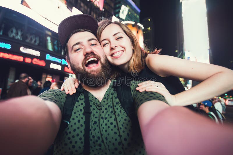 Happy dating couple in love taking selfie photo on Times Square in New York while travel in USA on honeymoon stock images Happy dating couple in love taking selfie photo on Times Square in New York while travel in USA on honeymoon stock images
