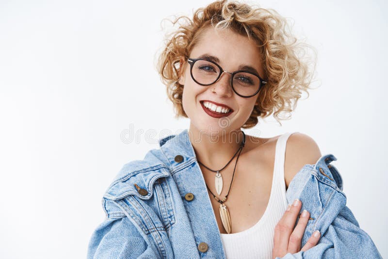 Happy delighted and attractive blond female with short curly hairstyle freckles and pierced nose wearing lipstick