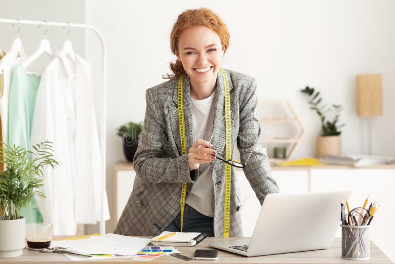 Happy designer woman work on computer in tailor workshop stock photos Happy designer woman work on computer in tailor workshop stock photos