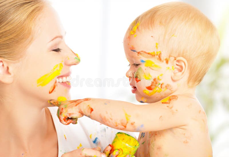 Allegra felice sporco bambino disegna dipinge sul volto della madre.