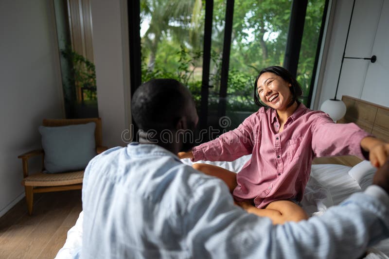 Happy and diverse couple sharing a joyful moment at home, embracing and smiling together royalty free stock photo