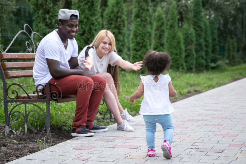 Happy diverse family with little daughter at park