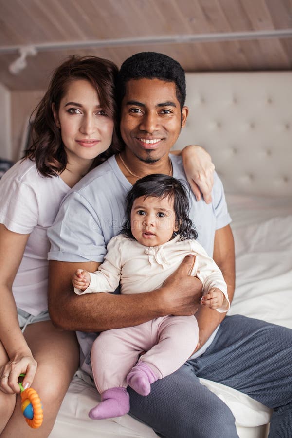 Happy diverse family looking at the camera indoors