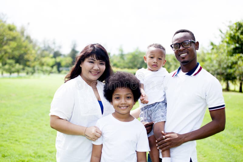 Happy diverse and mixed race family group photo in the park