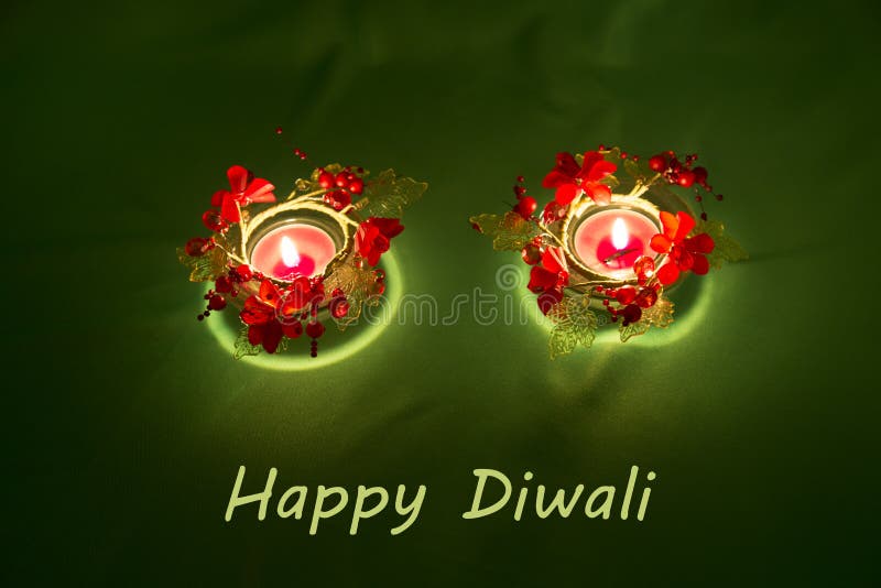 Happy Diwali. Traditional Indian festival green background with burning candles decorated with bright red flowers. Deepavali celeb royalty free stock photography Happy Diwali. Traditional Indian festival green background with burning candles decorated with bright red flowers. Deepavali celeb royalty free stock photography