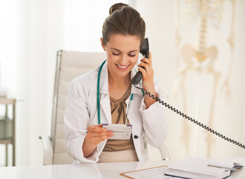 Happy doctor woman with calculator talking phone royalty free stock images Happy doctor woman with calculator talking phone royalty free stock images
