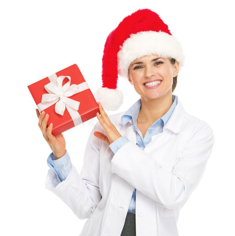 Happy doctor woman in santa hat showing christmas present box royalty free stock photography Happy doctor woman in santa hat showing christmas present box royalty free stock photography