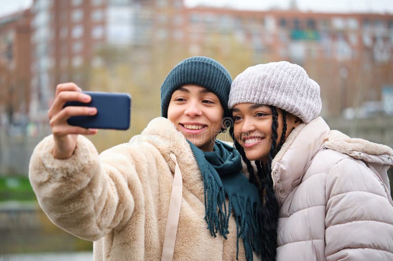 Happy Dominican Lesbian Couple With A Coffee Cup At Street In A Cold Winter Day Stock Image
