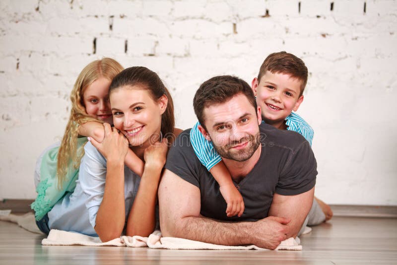Happy dreamy young couple of parents with their two children at home together royalty free stock image Happy dreamy young couple of parents with their two children at home together royalty free stock image