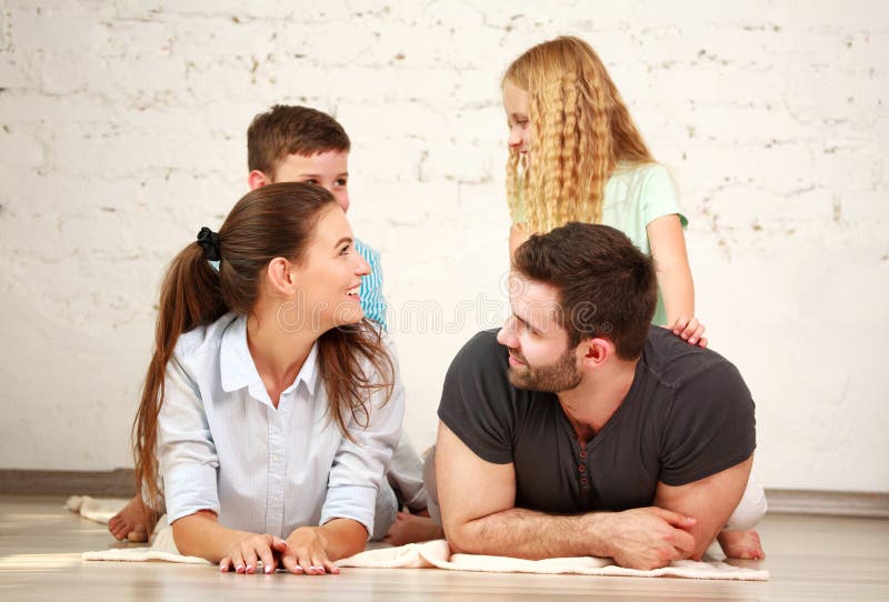 Happy dreamy young couple of parents with their two children at home together royalty free stock image Happy dreamy young couple of parents with their two children at home together royalty free stock image