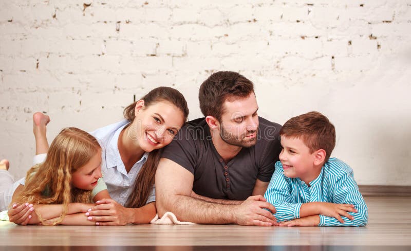 Happy dreamy young couple of parents with their two children at home together royalty free stock photography Happy dreamy young couple of parents with their two children at home together royalty free stock photography