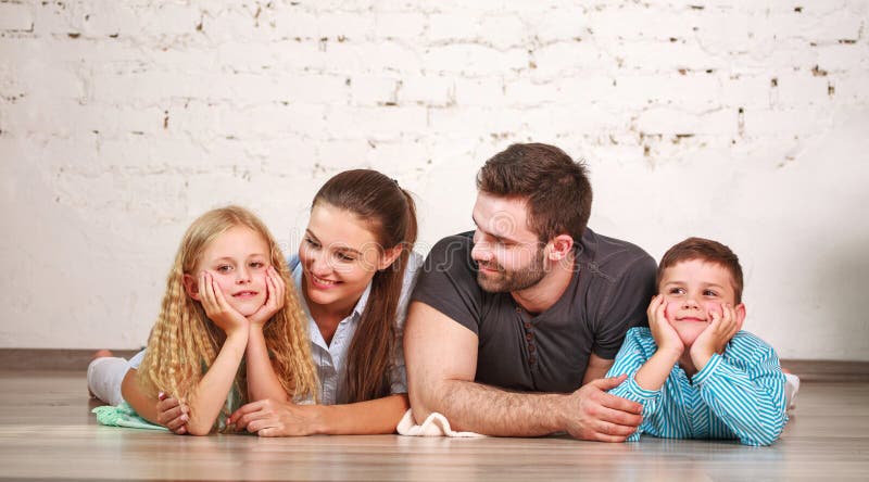 Happy dreamy young couple of parents with their two children at home together royalty free stock image Happy dreamy young couple of parents with their two children at home together royalty free stock image