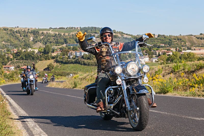 A happy driver leads a group of bikers riding Harley Davidson at motorcycle rally Sangiovese tour by Ravenna Chapter on September 22, 2013 in Riolo Terme (RA) Italy. A happy driver leads a group of bikers riding Harley Davidson at motorcycle rally Sangiovese tour by Ravenna Chapter on September 22, 2013 in Riolo Terme (RA) Italy