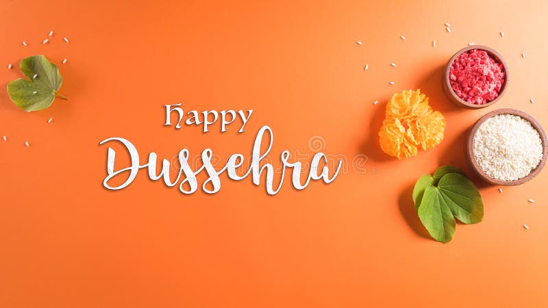 Happy Dussehra. Yellow flowers, green leaf and rice on orange background. Dussehra Indian Festival concept stock image