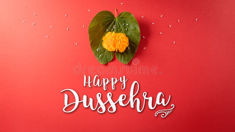 Happy Dussehra. Yellow flowers, green leaf and rice on red background. Dussehra Indian Festival concept royalty free stock photos