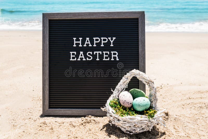 Happy Easter beach background with black board and eggs stock photography