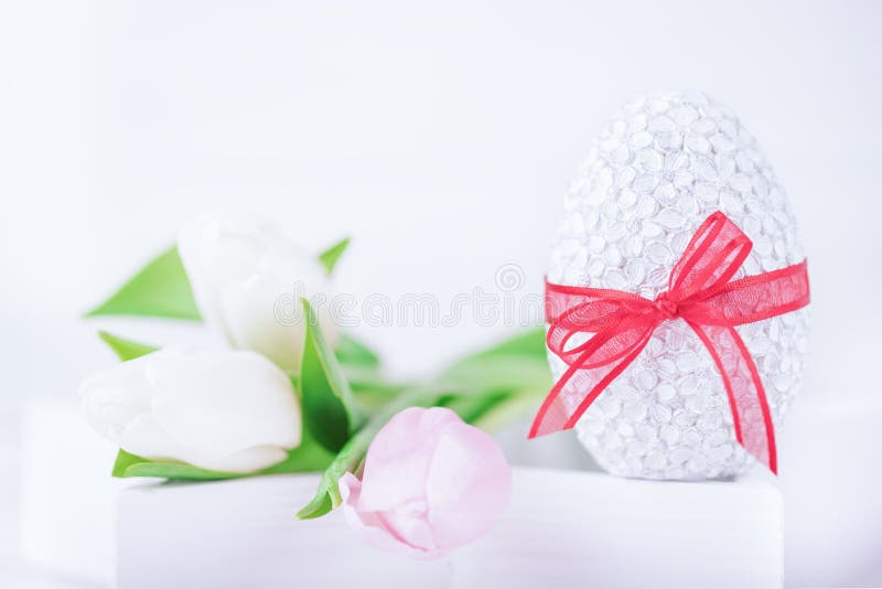 Happy Easter. Easter egg and delicate tulips on a white background. Copy space royalty free stock photo Happy Easter. Easter egg and delicate tulips on a white background. Copy space royalty free stock photo