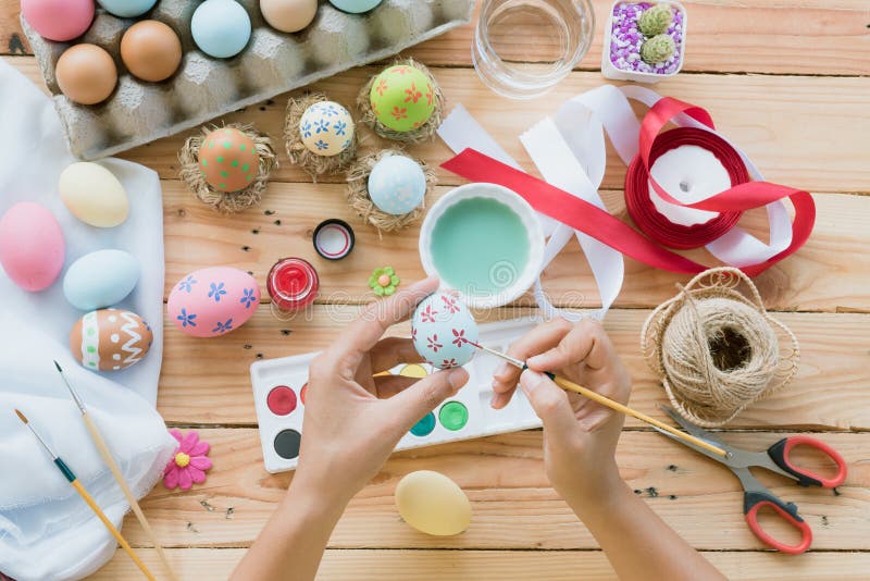 Happy easter! A woman hand painting Easter eggs. Happy family pr