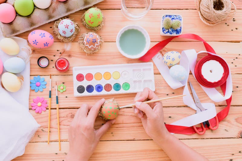 Happy easter! A woman hand painting Easter eggs.